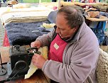 Fr&uuml;hlingsmarkt: Kirschner Rainer Gr&auml;ser n&auml;ht ein Kissen aus Schafsfell. (Foto: S. Schedwill)