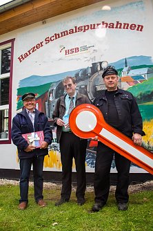 Pr&auml;sentierten am 23.08.2014 in Hasselfelde am Lokschuppen das neue Wandbild (v.l.n.r.): Der K&uuml;nstler Gunter Czyrnik; J&ouml;rg Bauer, Eisenbahnbetriebsleiter der HSB sowie Udo M&uuml;ller. (Foto: HSB)