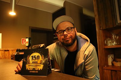 Hausleiter Christoph Rode mit dem Flyer zur Festwoche (Foto: Angelo Glashagel)