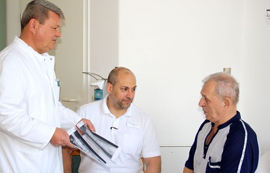 Michael Huttasch (li.) und Dr. Andreas Ubl (Mitte) zeigen Josef Heinz die R&ouml;ntgenbilder mit der Verst&auml;rkung seiner Wirbels&auml;ule nach der OP (Foto: Helios Bleicherode)