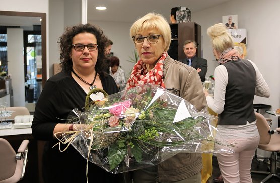 Anett Vollborth erh&auml;lt von Renate Gruben einen Blumenstrau&szlig; zur Begr&uuml;&szlig;ung in den neuen Salonr&auml;umen (Foto: St&auml;dtische Wohnungsbaugesellschaft)