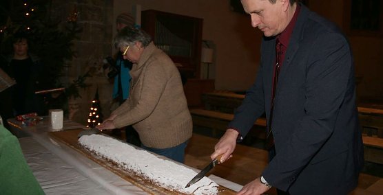 B&uuml;rgermeister Matthias Ehrhold und Pfarrerin Hilde J&uuml;ngling beim Stollenanschnitt. (Foto: S. Schedwill)