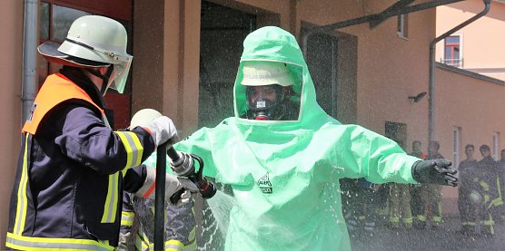 Ein Feuerwehrmann im Schutzanzug wird zu &Uuml;bungszwecken dekontaminiert. (Foto: Susanne Schedwill)