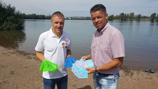 Der Renndirektor des ICAN Nordhausen, Ulrich Konschak, und Gesch&auml;ftsf&uuml;hrer der Badehaus Nordhausen GmbH, Jens Eisenschmidt, pr&auml;sentierten auch in diesem Jahr wieder die neu gestalteten Badekappen f&uuml;r die Athleten des Scheunenhof und ICAN-Triathlons am kommenden Wochenende. (Foto: Marco Bachmann)