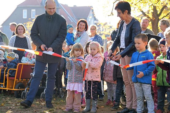 Henry Pasenow und Helga Tamaschke erhalten von den Kindergartenkindern beim Banddurchschnitt Hilfe.  (Foto: Susanne Schedwill)