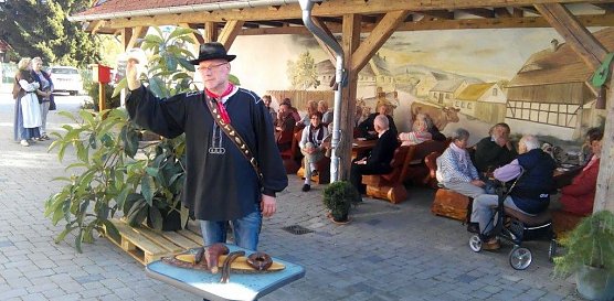 Brockenbauer Uwe Thielecke erl&auml;utert der Reisegruppe der Landsenioren aus dem S&uuml;dharz seinen Bauernhof. Vor ihm auf dem Holzbrett: Wurstspezialit&auml;ten des Hauses. (Foto: Kurt Frank)