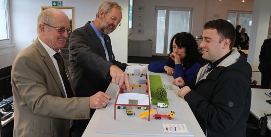 v.l.: Prof. Dr. Poerschke, Prof. Fl&uuml;ggen, Petra Hausschild und Andreas Grimm am Modell ihres neuen Forschungszentrums (Foto: Angelo Glashagel)