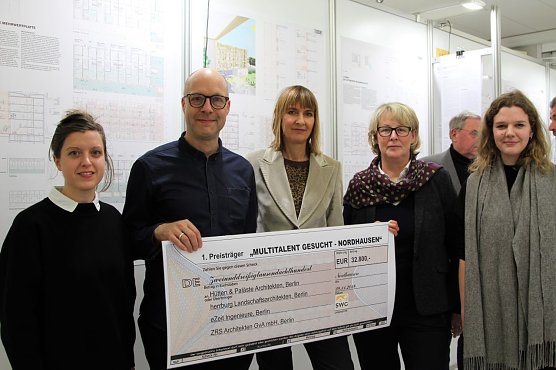 Die Berliner Architekten Nanni Grau und Frank Sch&ouml;nert von H&uuml;tten & Pal&auml;ste sowie ihre Mitarbeiterinnen Sophia Albrecht und Franziska Heidecker vor ihrem Siegerentwurf mit SWG-Chefin Inge Klaan.   (Foto: Susanne Schedwill)