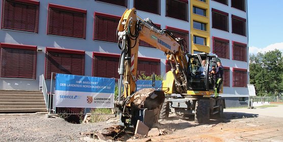 Spatenstich mit Bagger: Landrat Matthias Jendricke l&auml;utete gestern Nachmittag den letzten Bauabschnitt am Schulhof der Ellricher Oberschule ein (Foto: agl)