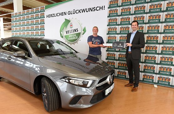 Freudig und &uuml;berrascht zugleich war Lars Dietrich (links) als er sein neues Auto von Veltins-Mitarbeiter Patrick Krause entgegennahm. (Foto: Veltins)