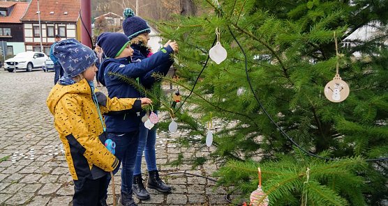 Lisa, Ludwig und Ida schm&uuml;cken mit ihren Anh&auml;ngern den Baum auf dem Georgsplatz (Foto: Susanne Schedwill)