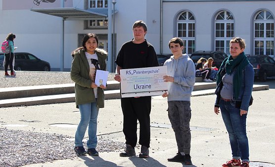 Fereshta Akhlagi, Alexander L&ouml;schner und Obada Chanan &uuml;bergeb Geld und Scheck an  Stephanie Tiepelmann-Halm (v.l.n.r.) (Foto: oas)