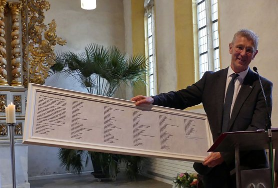 Dr. Christoph Maletz pr&auml;sentiert die Spendertafel, die kurz darauf unter dem Fenster ihren Platz findet (Foto: Evangelischer Kirchenkreis S&uuml;dharz)