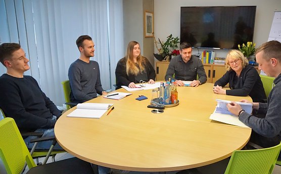 Florian Kellner, Dennis K&ouml;hring, Nicole H&ouml;hne, Daniel Kruse und Christian Kaufmann (v.l.n.r.) studieren neben ihrer Arbeit an einer Fernuni. Mit SWG-Gesch&auml;ftsf&uuml;hrerin Inge Klaan besprechen sie das gemeinsame Projekt Kurze Stra&szlig;e, bei dem sie die Uni-Inhalte auf die Praxis anwenden. (Foto: SWG/S. Schedwill)