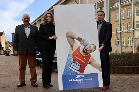 Meeting-Direktor Werner H&uuml;tcher, Jana Z&ouml;ller, Gesch&auml;ftsf&uuml;hrerin der Nordh&auml;user Energieversorgung, sowie Jan Oberb&uuml;chler, Vorstand der Nordh&auml;user Kreissparkasse pr&auml;sentieren Bob Bertemes den Sieger des Kugelsto&szlig;meetings 2023 f&uuml;r die Ahnengalerie in der Wiedigsburghalle (Foto: Jessica Piper)