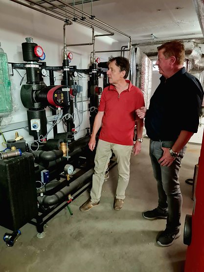 Planer Elko Vopel und SWG-Projektleiter Steffen Peter (r.) besprechen vor der neuen Fernw&auml;rme&uuml;bergabestation im Keller des Seniorenwohnblocks letzte Details (Foto: SWG/Susanne Schedwill)