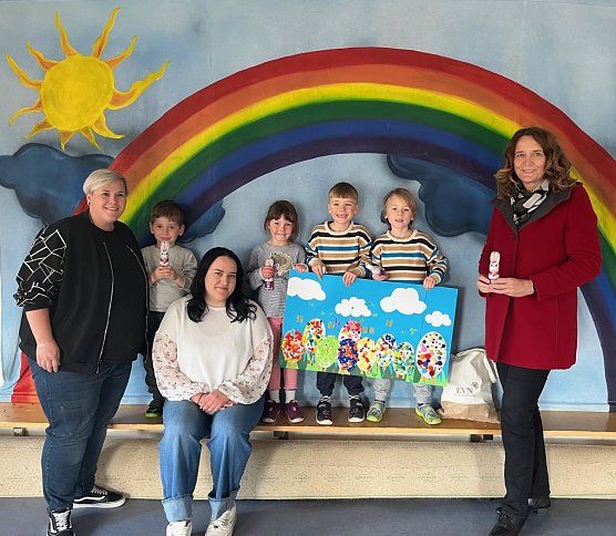 Jana Z&ouml;ller &uuml;bergibt den Kindern der Integrativen Kindertagesst&auml;tte Traumzauberbaum und dem Team rund um Kita-Leiterin Franziska Kanzler 50 Schoko-Osterhasen. (Foto: EVN)