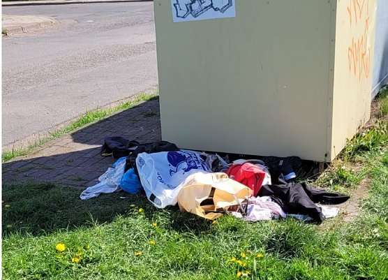Kleiderberge vor einem Container (Foto: A.Adlerauge)