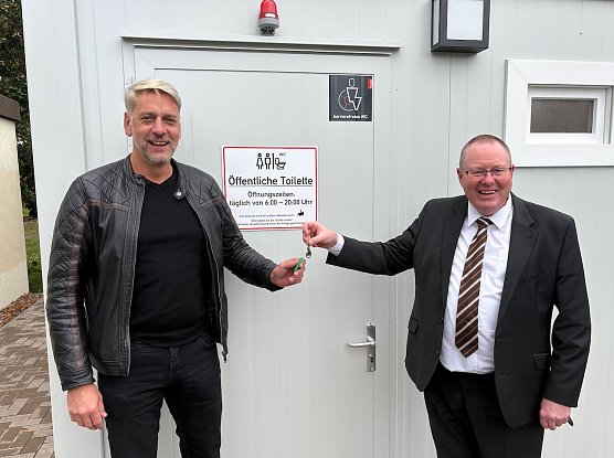 Thorsten Schwarz, Gesch&auml;ftsf&uuml;hrer der Verkehrsbetriebe Nordhausen, und Harztors B&uuml;rgermeister Stephan Klante &uuml;bergeben symbolisch den Schl&uuml;ssel zur neuen &ouml;ffentlichen Toilette am Bahnhof Niedersachswerfen Ost.  (Foto: Dirk Daniel)