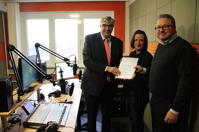 TLM Leiter Jochen Fasco &uuml;bergab Senderchefin Sandra Witzel und Vereinsvorstand Sebastian Gerecke die Lizenz f&uuml;r die kommenden vier Jahre (Foto: Angelo Glashagel)