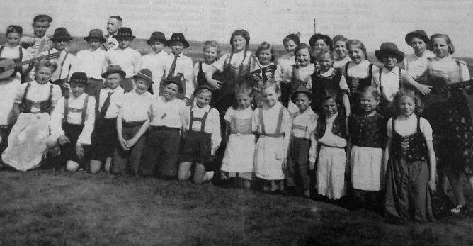 Dieses Foto entstand am 1. Mai des Jahres 1950. Es zeigt den damaligen Schulchor. Ganz links Erika Nebelung mit Gitarre, dahinter Lehrer Gerhard Stolz. Im Hintergrund rechts daneben Schulleiter Otto Lerp. (Foto: privat)