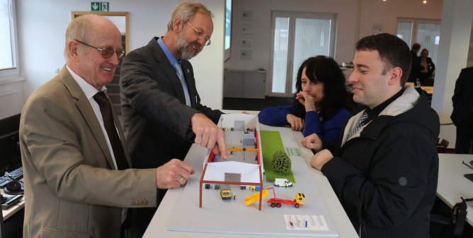 v.l.: Prof. Dr. Poerschke, Prof. Fl&uuml;ggen, Petra Hausschild und Andreas Grimm am Modell ihres neuen Forschungszentrums (Foto: Angelo Glashagel)