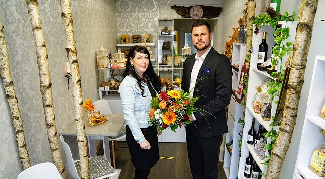Mandy Neblung hat am Kornmarkt 7, im Erdgeschoss der Wohnh&auml;user am Kreisel in Nordhausen, ihre Wein- und Naschstube er&ouml;ffnet. Pascal Wetzler von der SWG &uuml;berbrachte zum Start Blumengr&uuml;&szlig;e.  (Foto: SWG/Susanne Schedwill )