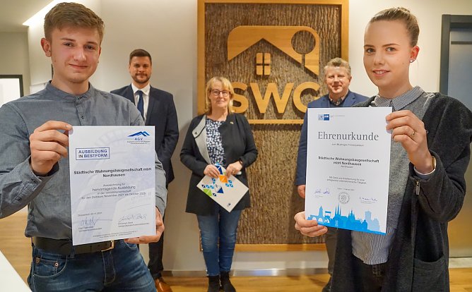 Gleich zwei Urkunden gab es jetzt f&uuml;r die SWG: Bachelorstudent Moritz Burghardt und Immobilienkauffrau-Auszubildende Luisa Gr&auml;&szlig;er pr&auml;sentieren die Urkunden der IHK und des AGV in den Gesch&auml;ftsr&auml;umen der SWG in Nordhausen. Christian B&ouml;duel (hinten rechts) von der IHK &uuml;berbrachte SWG-Chefin Inge Klaan und Pascal Wetzler, Gesch&auml;ftsf&uuml;hrer der Objektmanagement GmbH, Gl&uuml;ckw&uuml;nsche zum Firmenjubil&auml;um.  (Foto: S.Schedwill)