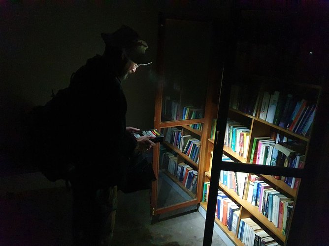 Hier sind wir nicht in eine fremde Wohnstube eingedrungen: In Morungen gibt es eine exklusive Bushaltestelle mit reich gef&uuml;llten B&uuml;cherschr&auml;nken zur kostenlosen Bedienung. Wanderfreund Christian aus Jena l&auml;sst es sich nicht nehmen, im Schein seiner Taschenlampe ein wenig zu st&ouml;bern und schlie&szlig;lich ein Buchexemplar in seinen Rucksack zu stecken.  (Foto: Bodo Schwarzberg)