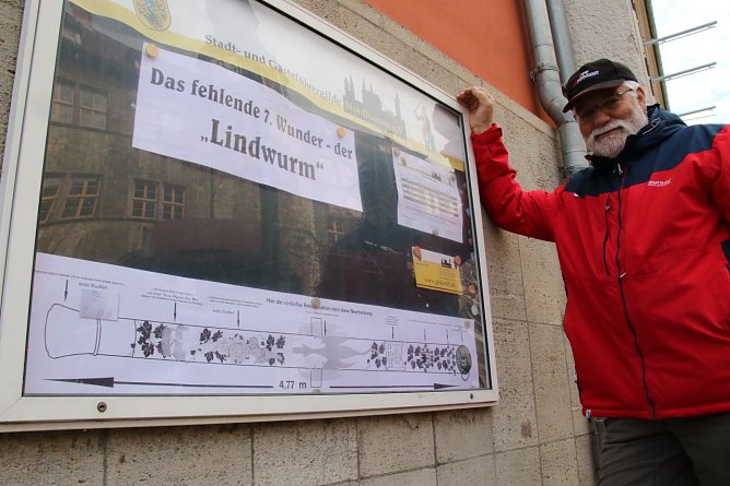 Michael Garke vor dem Schaukasten der Gästeführergilde und seiner Vision vom "Lindwurm" (Foto: agl) Michael Garke vor dem Schaukasten der Gästeführergilde und seiner Vision vom "Lindwurm" (Foto: agl)