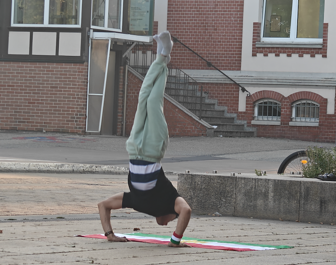 Sportlicher Flaggenhandstand auf dem Bahnhofsplatz (Foto: Peter Blei) Sportlicher Flaggenhandstand auf dem Bahnhofsplatz (Foto: Peter Blei)