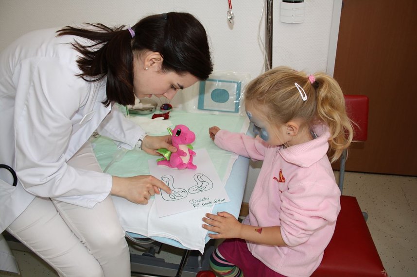 Assistenz&auml;rztin Tina Droste (li.) erkl&auml;rt Greta M&uuml;nchow (4, re.) das R&ouml;ntgenbild ihres verletzten Drachens.