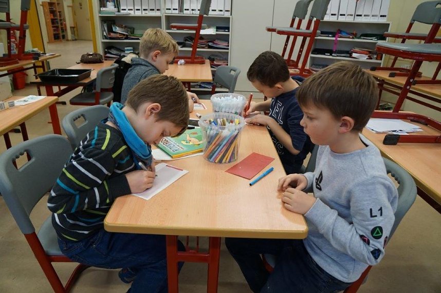 Die Jungen bemalen T&uuml;ten, in die Pl&auml;tzchen hineinkommen. 