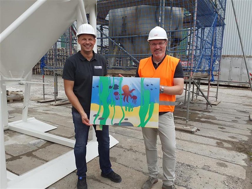 Projektteilnehner mit ihren Entw&uuml;rfen vor den einger&uuml;steten Silos