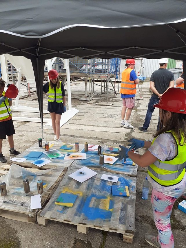 Projektteilnehner mit ihren Entw&uuml;rfen vor den einger&uuml;steten Silos