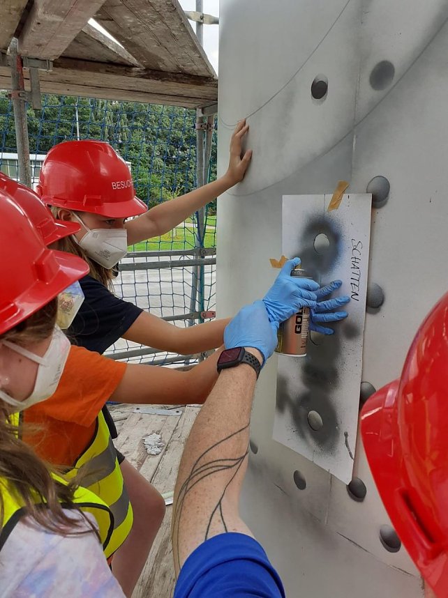 Projektteilnehner mit ihren Entw&uuml;rfen vor den einger&uuml;steten Silos