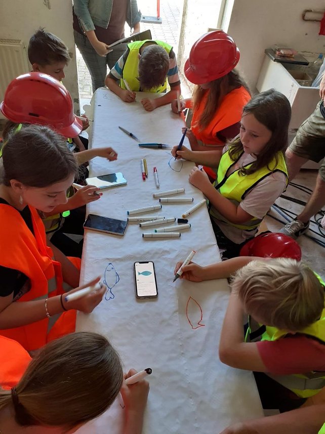 Projektteilnehner mit ihren Entw&uuml;rfen vor den einger&uuml;steten Silos