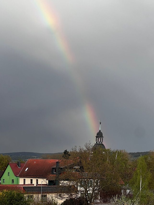Der Regenbogen zielt genau auf die Kirchturmspitze in Sundhausen. 